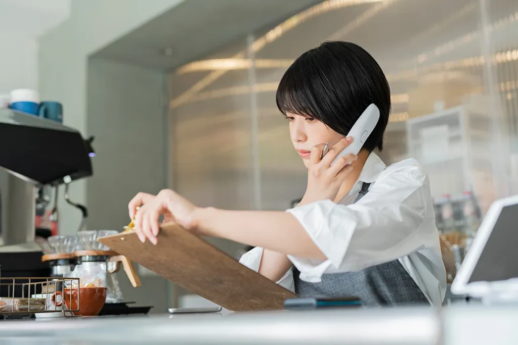 電話をするカフェ店員