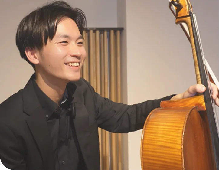 チェロを持って笑う男性