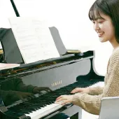 楽譜を見ながらピアノを弾く様子